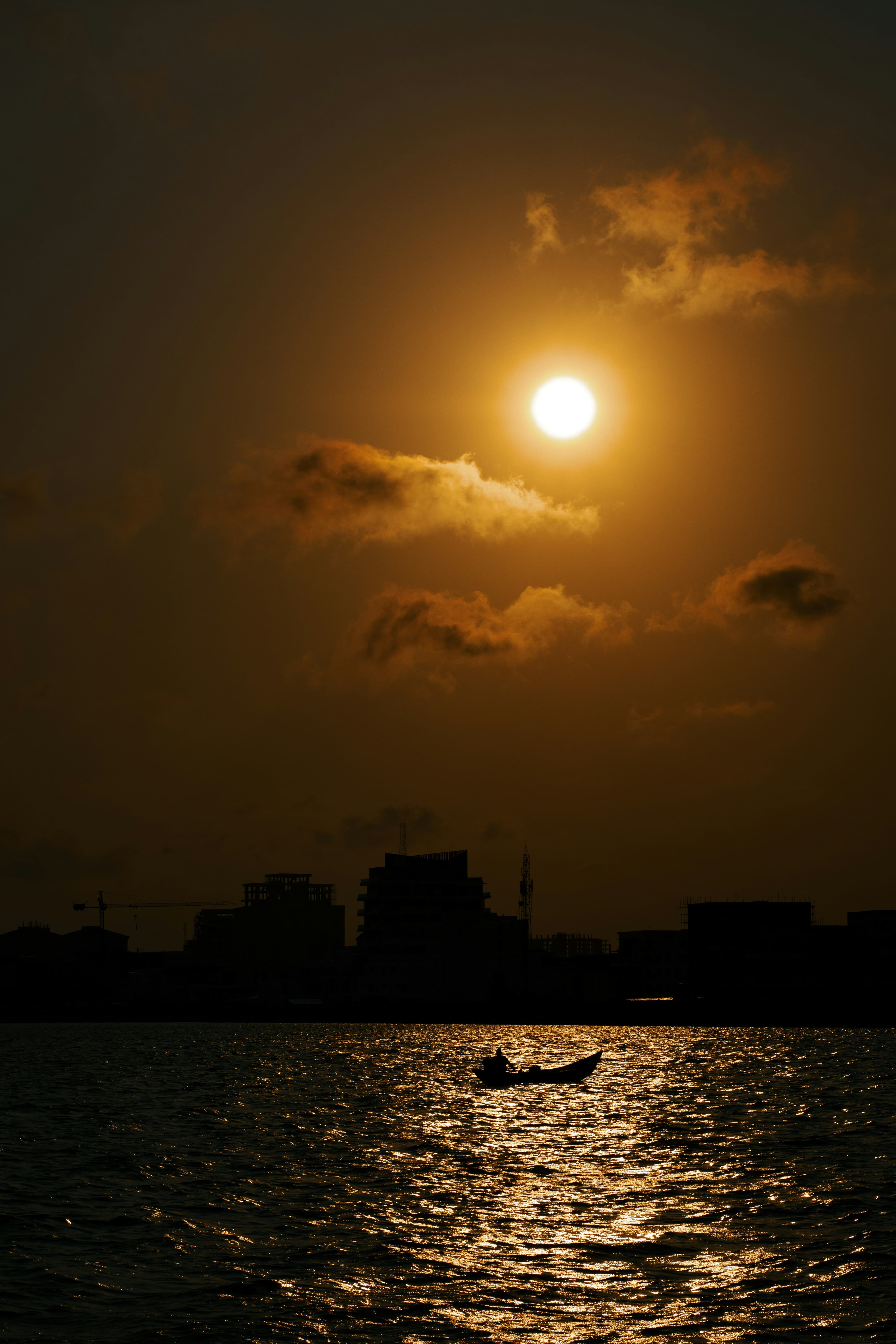 The sun setting over the lagoon, a lone boat silhouetted against the water.