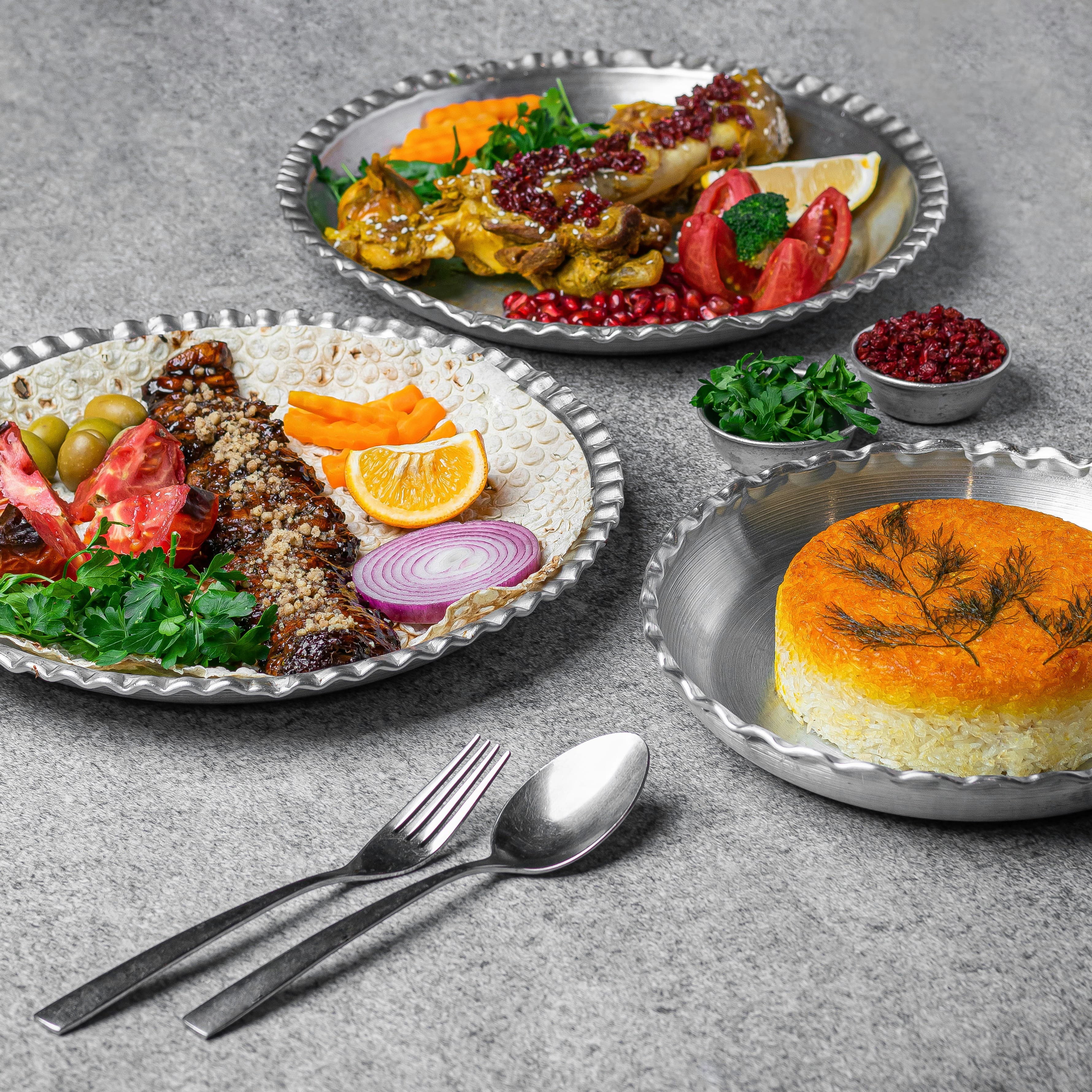 A shared spread of rice, roasted chicken, and kebab set out for a group meal.