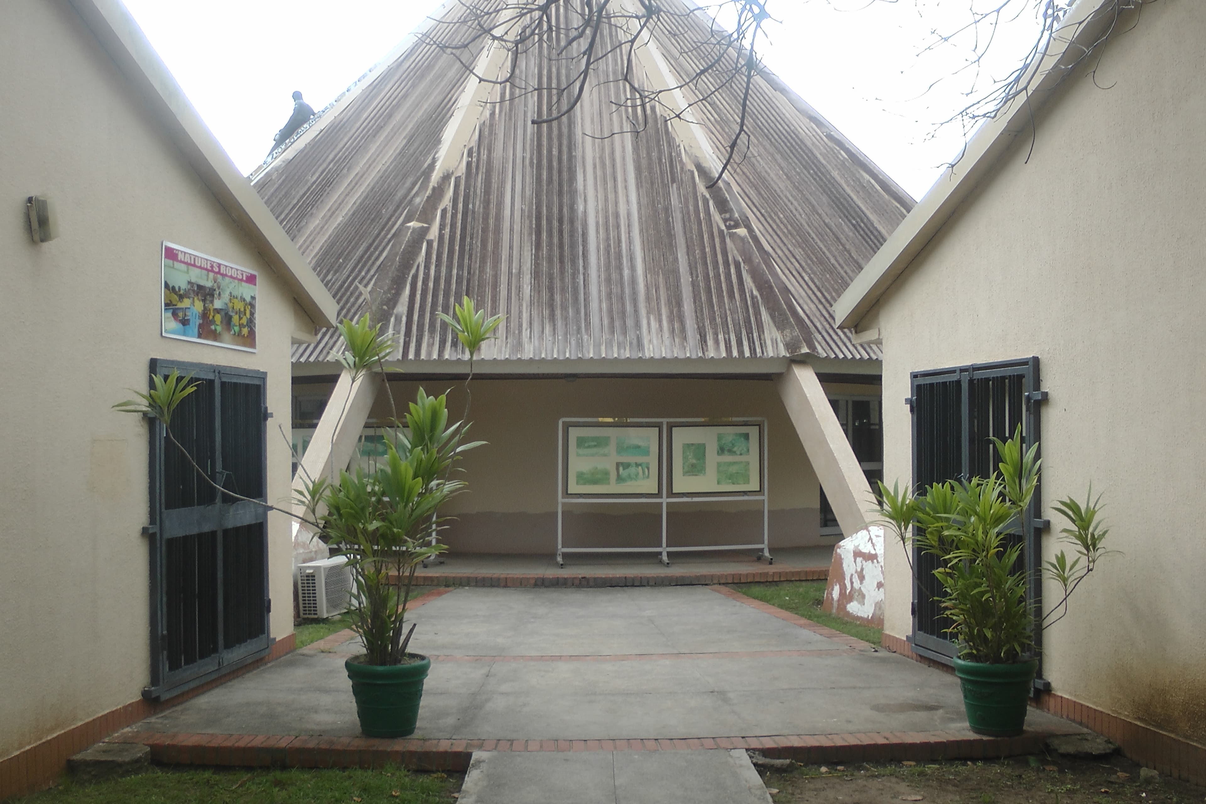 The entrance courtyard at Lekki Conservation Centre, framed by a peaked thatch roof.